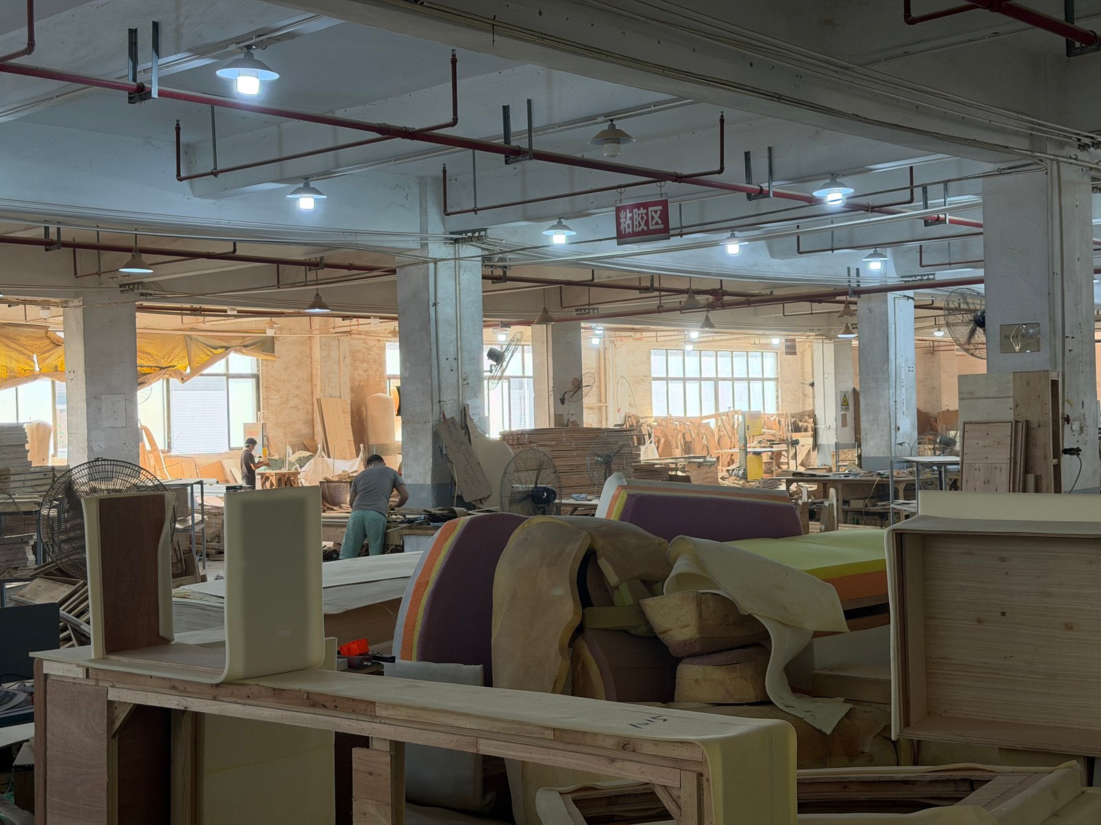 Furniture frames and upholstery work visible inside the Lenatees Foshan production site