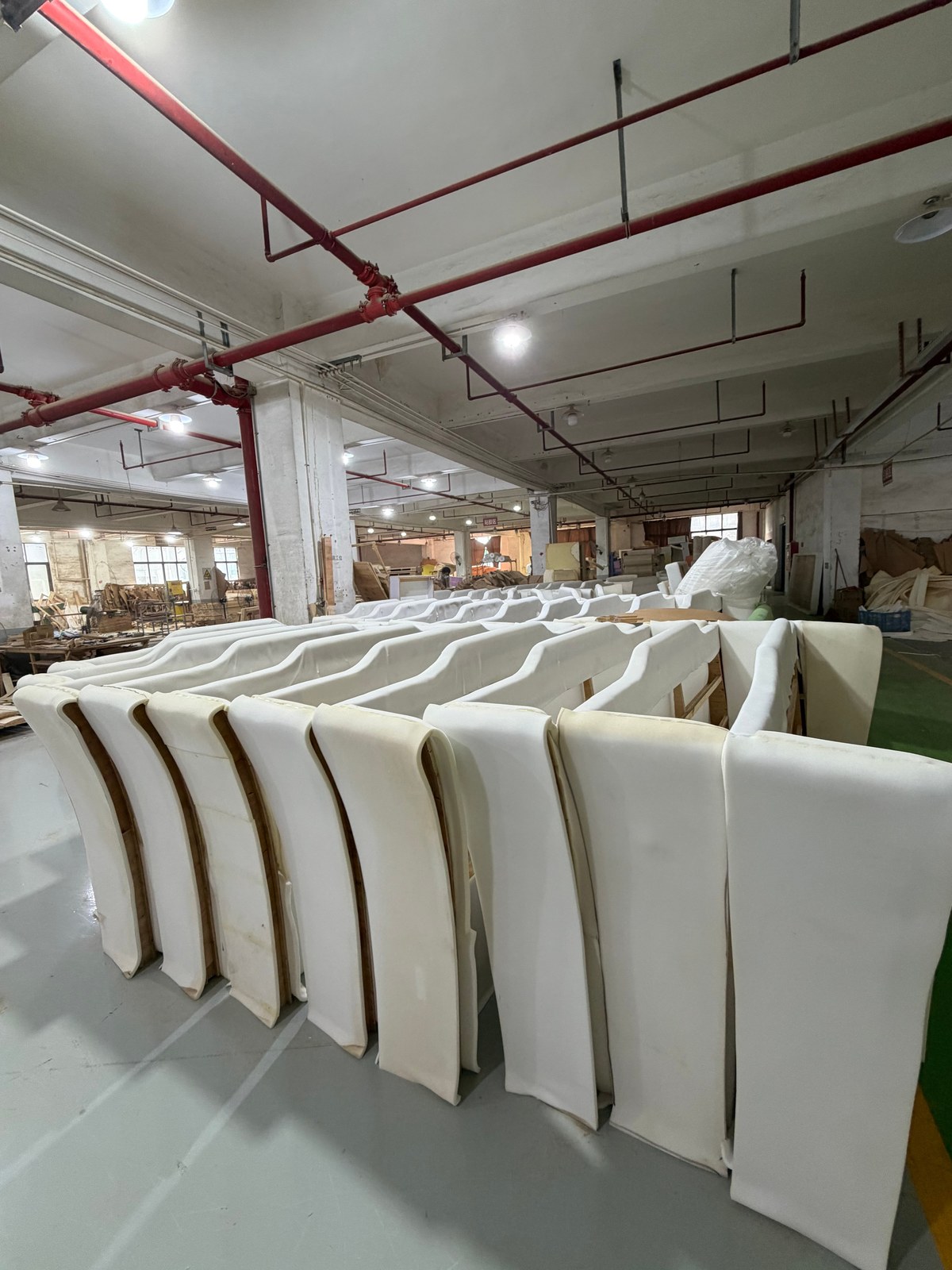 Multiple similar upholstered furniture units staged as work in progress