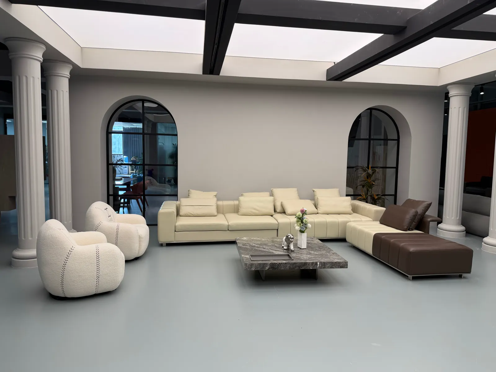 Sectional sofa, lounge chairs and coffee table arranged for finish and scale review in a Foshan showroom