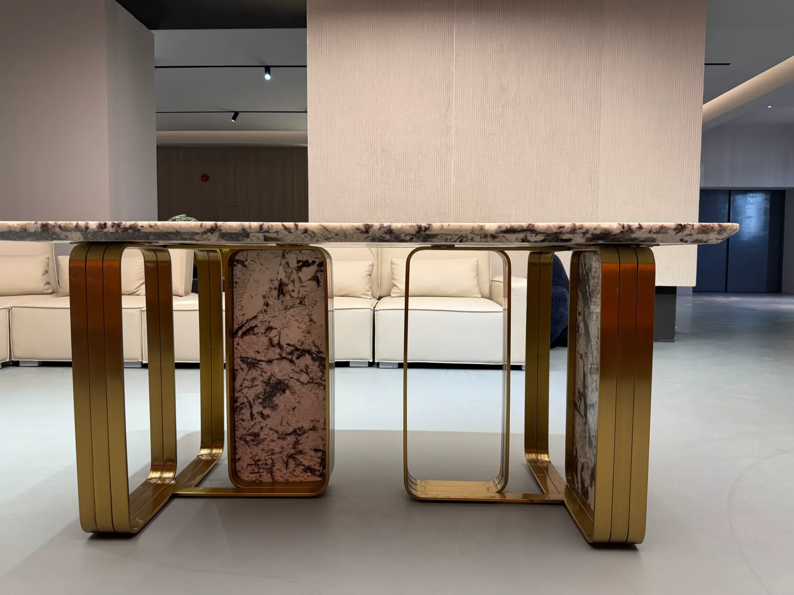 Finished table with a light stone-pattern top and gold-tone frame in a Foshan furniture display area