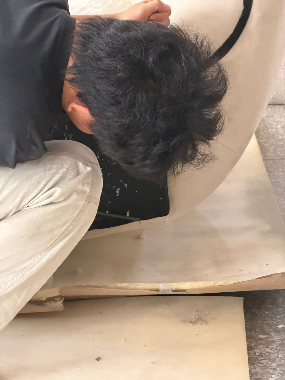 Worker fitting an interior layer inside an upholstered furniture shell in the Foshan workshop
