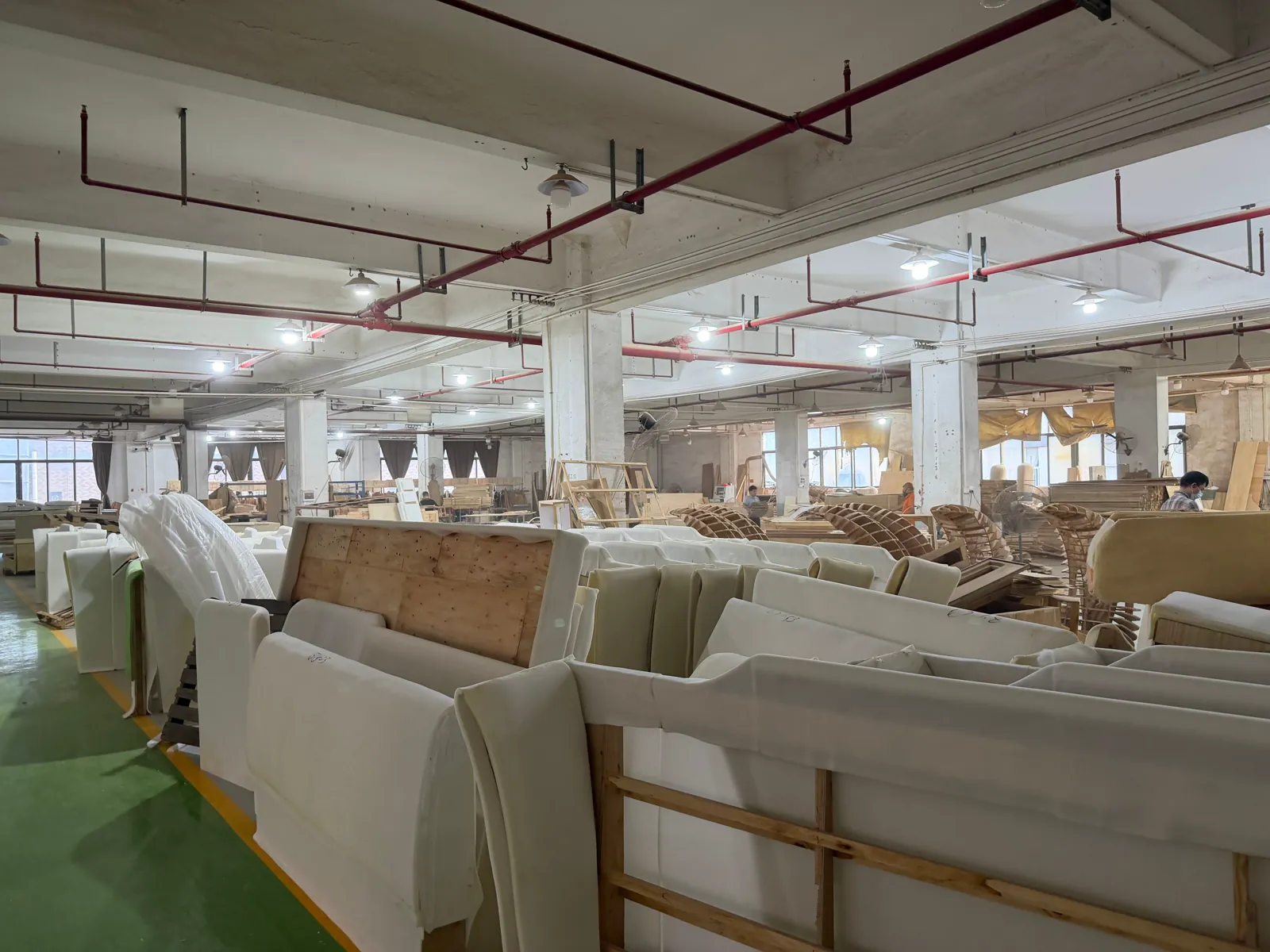 Upholstered furniture frames and components visible across the Foshan production floor