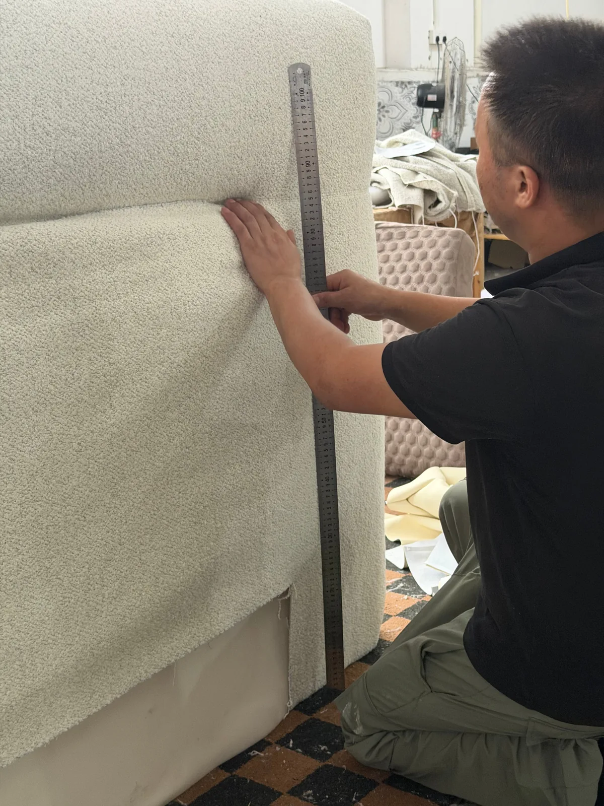 Worker fitting upholstery to a custom sofa frame