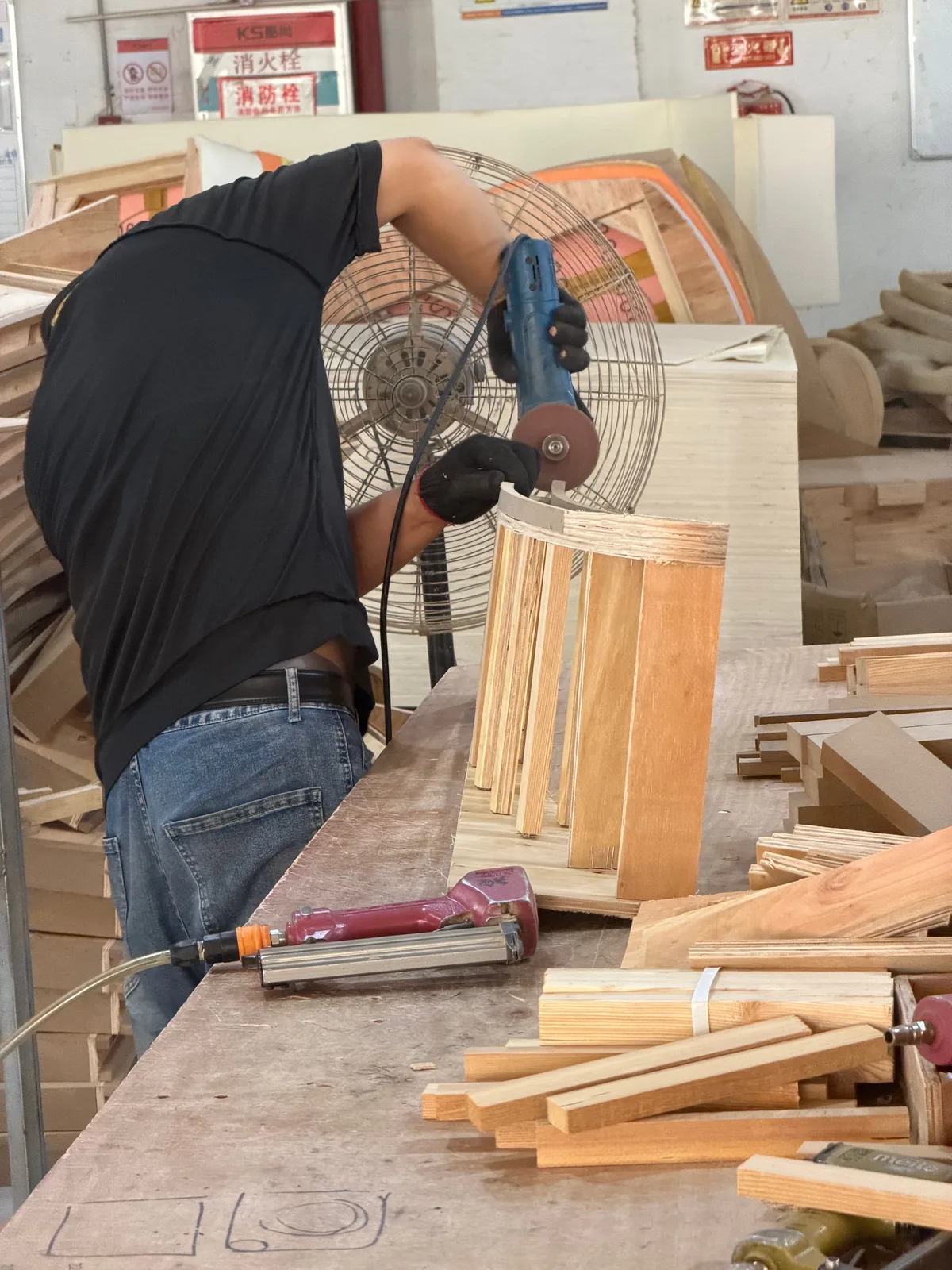 Worker assembling a custom furniture wood frame in the Foshan workshop