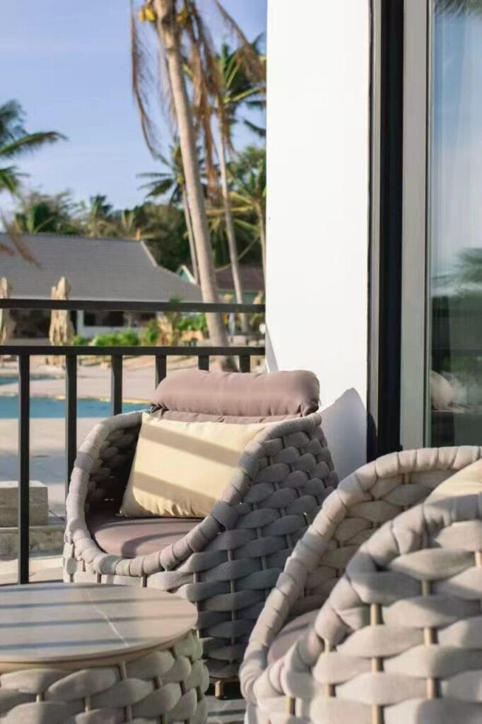 Woven outdoor chairs and table on a resort balcony