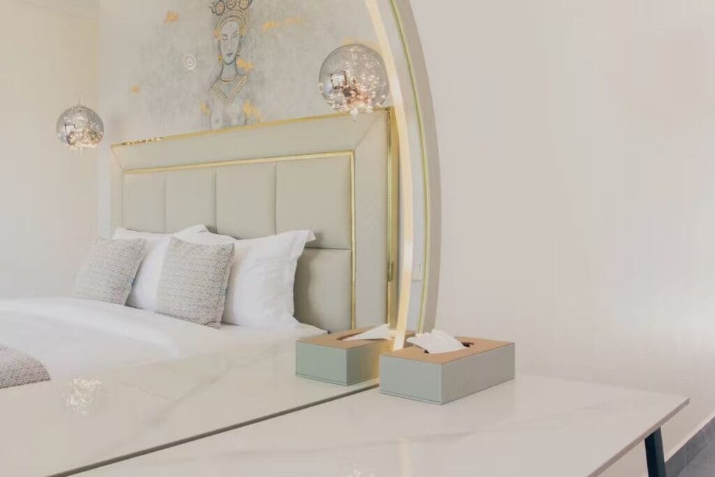 Upholstered hotel headboard with decorative metal trim and dresser surface