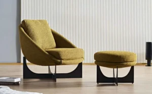 Mustard LC23-35 sculptural lounge chair with a curved shell and dark geometric base shown beside a round ottoman