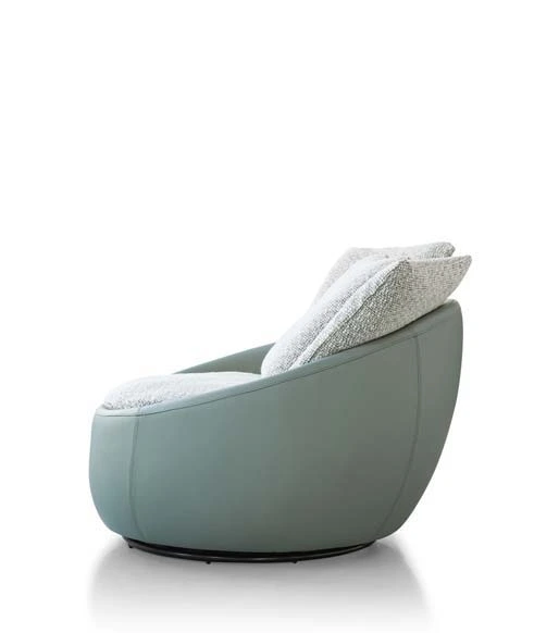 Side view of the LC23-41 rounded lounge chair with a pale green shell, light cushions and a low dark circular base