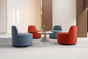 Four LC25-09 armless lounge chairs in rust-red and muted blue arranged around a small table indoors